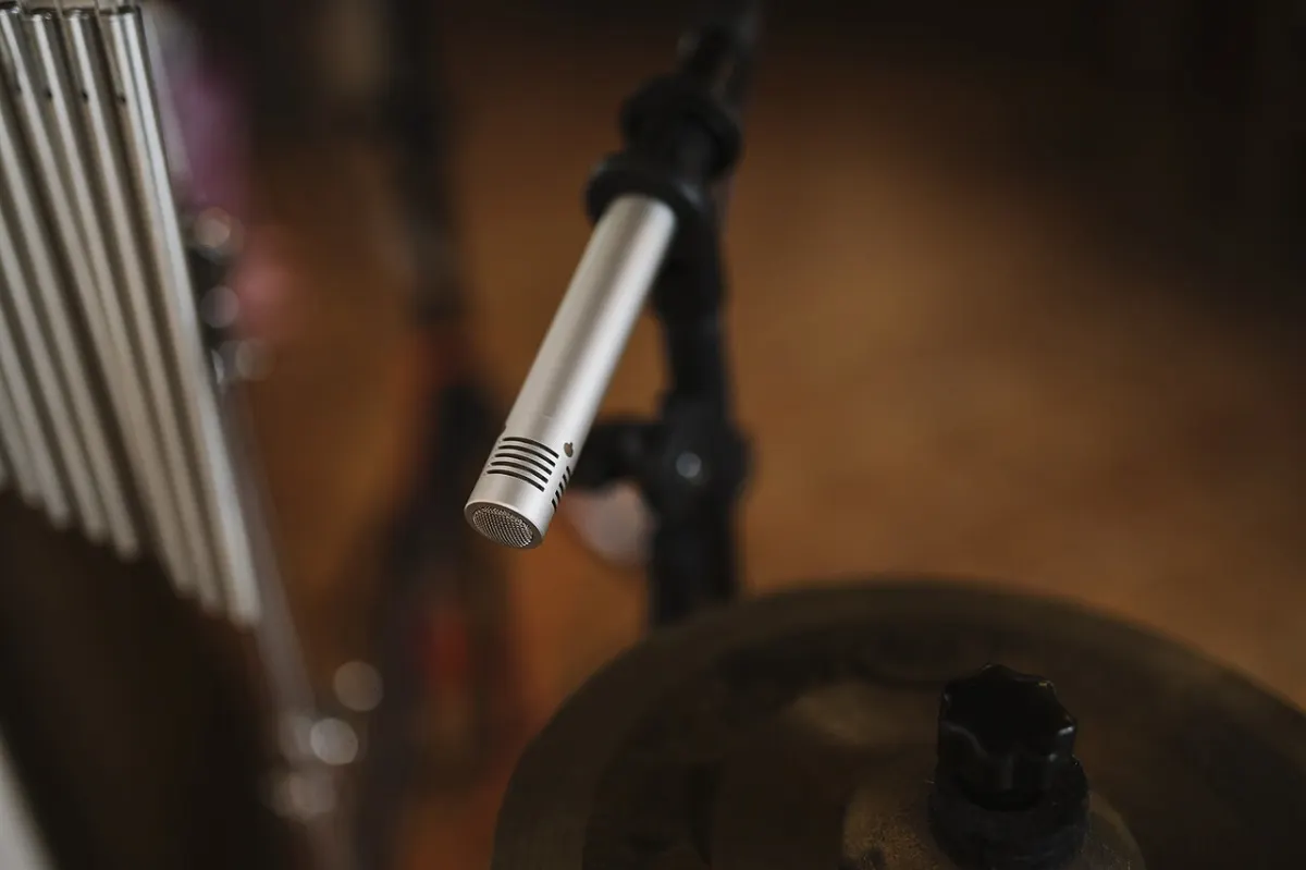 Audio Recorder Software - Microphone poised above drums in a cozy studio setting undefined