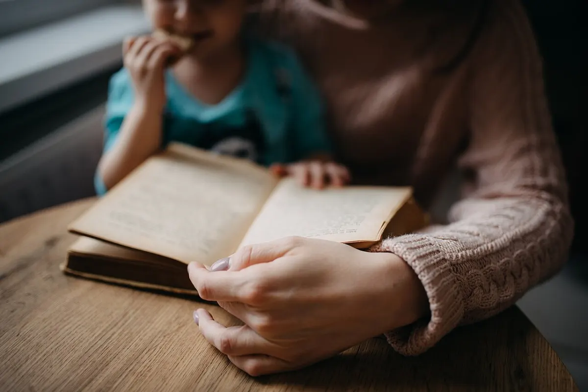 Book Review Website - Mother reading book to daughter closeup