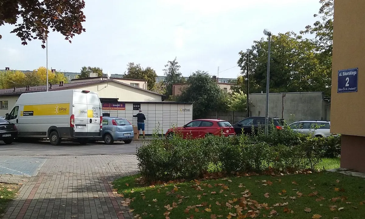 Courier Management System - An employee of the InPost courier company while handling a parcel locker