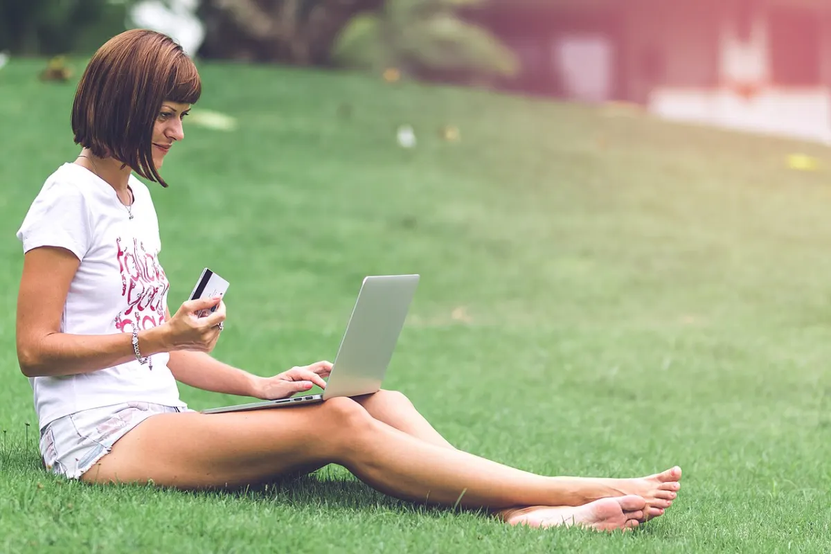 Multi-Vendor E-Commerce Platform - Woman online shopping concept. Woman in the green park with modern laptop. Bali island