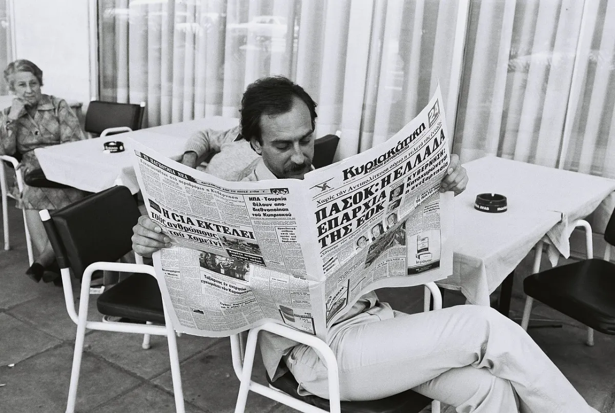 News Reader App - Man reading a newspaper at a café terrace in Athens, Greece - 1979