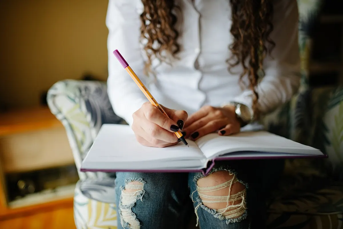 Note Taking App - Hands of a woman writing notes in her planner closeup