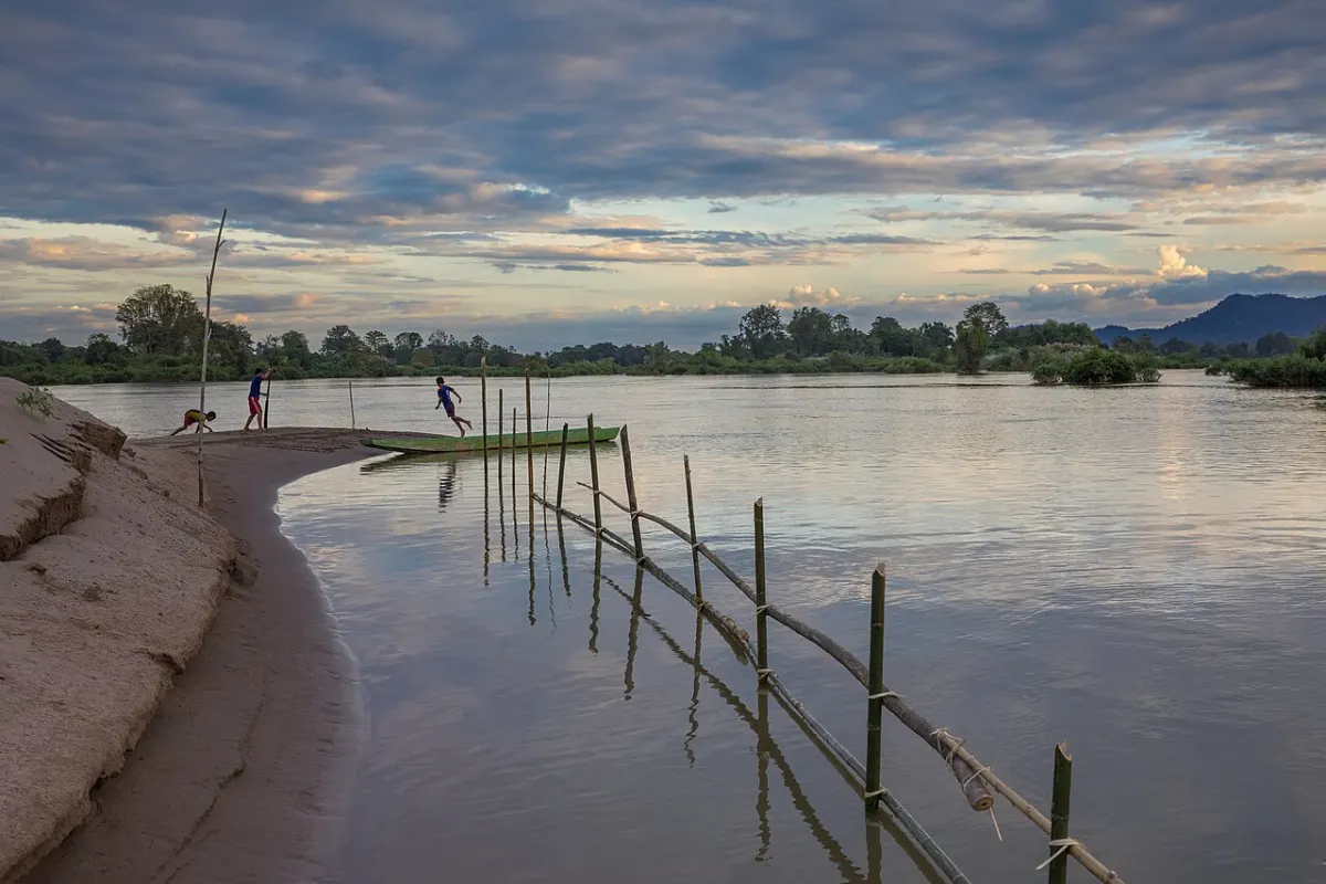 Orphanage Management System - Children playing at sunset on a Mekong bank in Si Phan Don