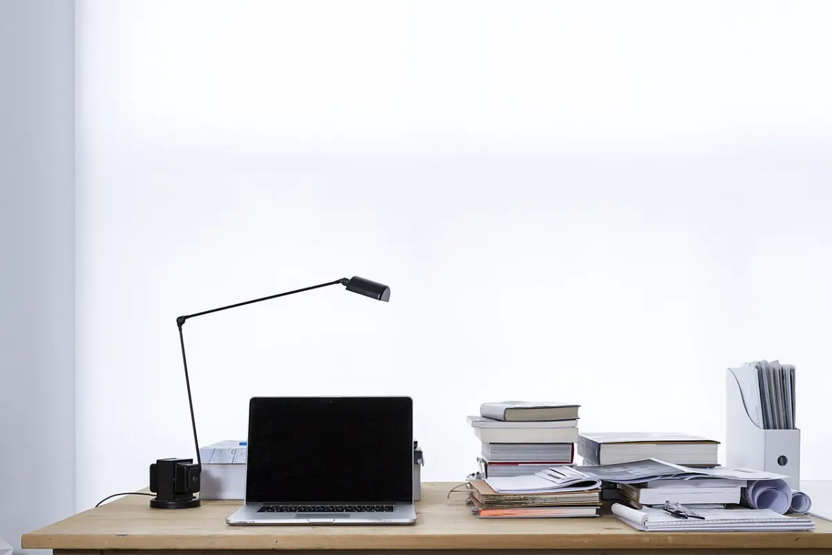Personal Finance Dashboard - Laptop on desk book stacks (Unsplash)