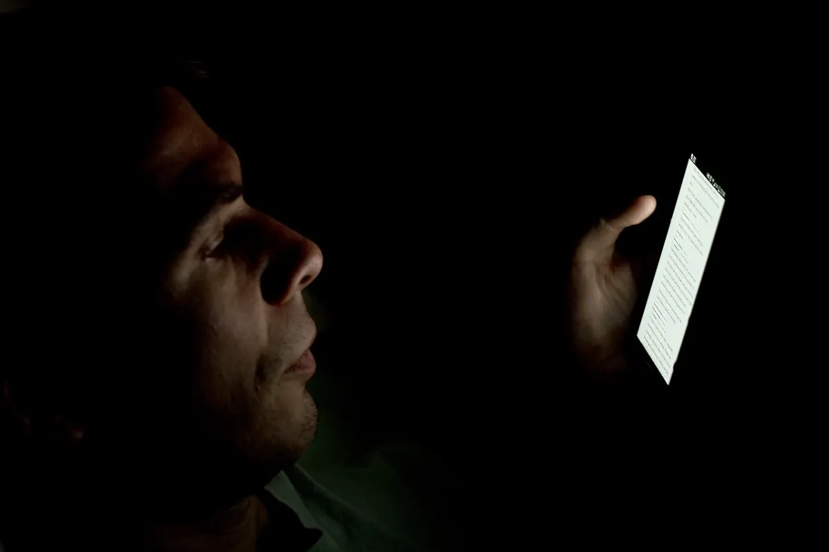 Screen Time Monitor App - Person looking at smartphone in the dark